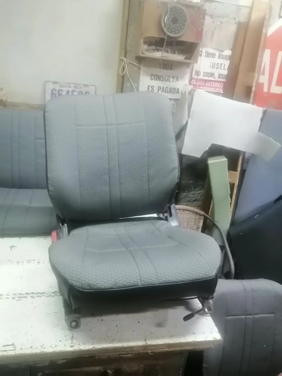 Asiento de conductor forrado en tela automotriz gris con base de vinil negro