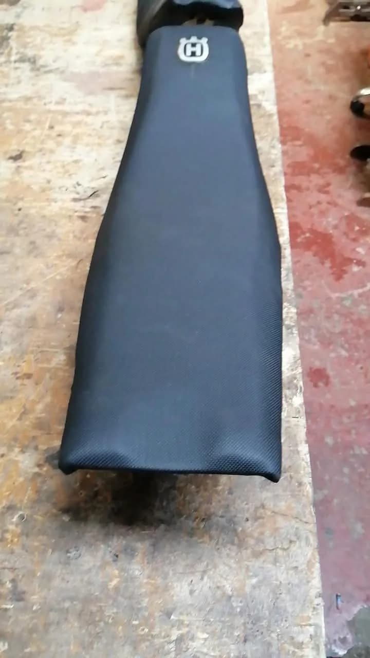 Asiento de motocicleta todoterreno forrado en vinil antideslizante negro con emblema de la marca